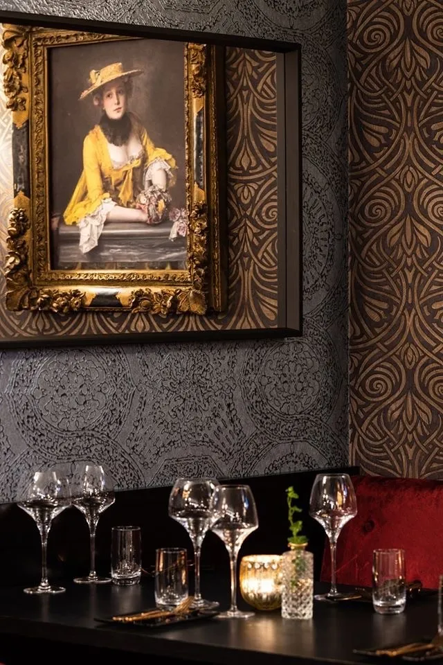 Restaurant Alma – Tønsberg: maleri i gullramme på mørk, mønstret tapet