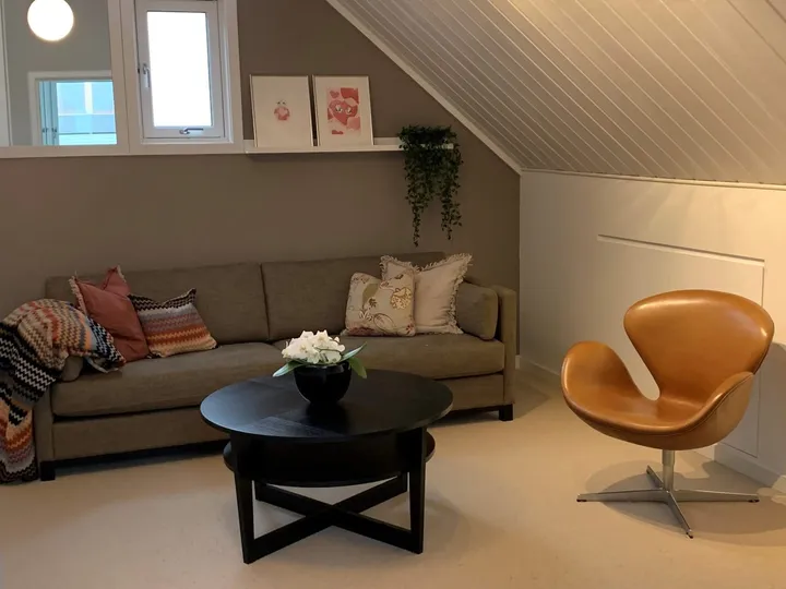 Loftstue: loftsstue med sofa, salongbord og en oransje lenestol