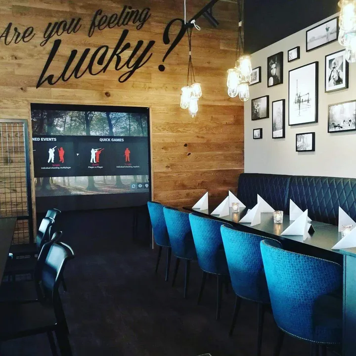 Lucky Bowl: spisesal med blå fløyelsstoler, trepanel, innrammede bilder og en skjerm på veggen
