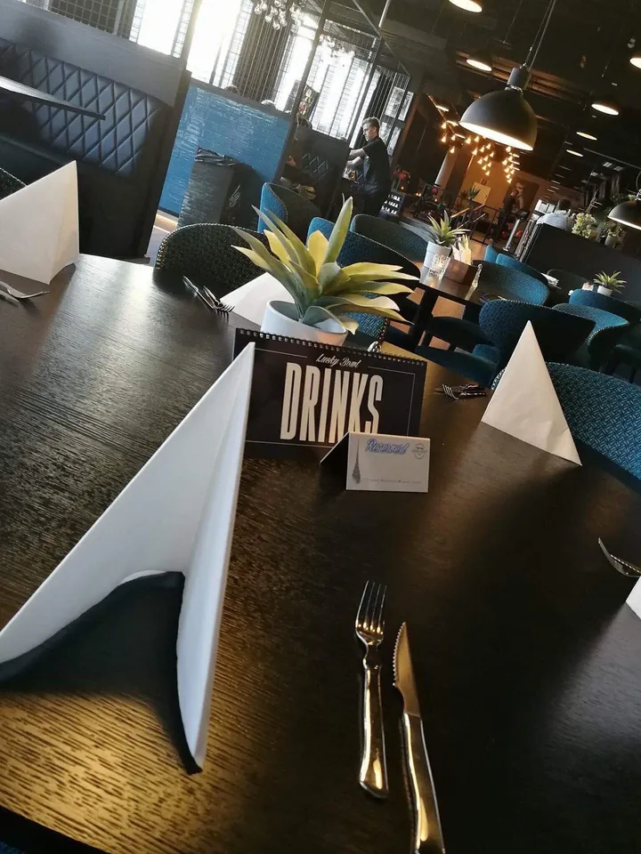 Lucky Bowl: dekket bord med et menyskilt «Drinks» og blå stoler